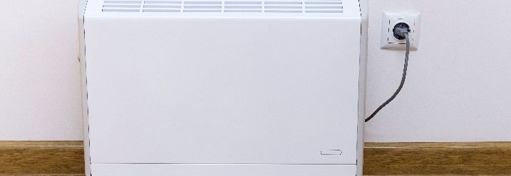 Ein weißer Elektroheizkörper an einer Wand.